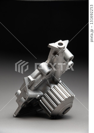 Top-quality parts for your car. Car maintenance. New water pump for a car's engine cooling system on a gray gradient background. 131692253