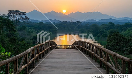 Wooden Bridge at Sunset Over River with Mountainous Backdrop 131692575