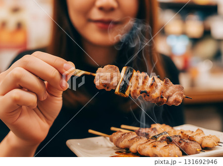 香ばしい煙と熱々ジューシーな焼き鳥。日本の居酒屋で楽しむ至福の瞬間 131692946