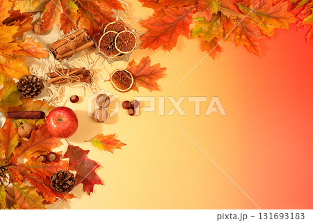 Autumn banner or screensaver, greeting card, abstract composition with maple leaves, pine cones, nuts, cinnamon, star anise and dried oranges, still life and Thanksgiving concept. 131693183