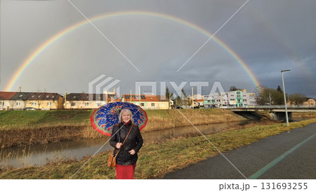 woman with  colorful umbrella and rainbow in the background 131693255