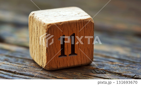 Wooden block with the number "11" etched on it, resting on a textured wooden surface. Concept of simplicity and rustic charm. For calendars Wooden block with the number "11" etched on it, resting on a textured wooden surface. Concept of simplicity and rustic charm. For calendars 131693670