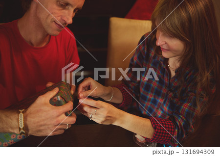 Warm Gift Exchange Between a Couple At Home, Cozy Holiday Moment With Wrapped Present 131694309