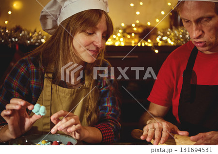 Warm Christmas Baking Scene With Couple Chefs Preparing Candies In Cozy Kitchen Warm Christmas Baking Scene With Couple Chefs Preparing Candies In Cozy Kitchen 131694531