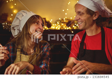 Joyful Cooks Share a Warm, Festive Moment in a Cozy Kitchen Joyful Cooks Share a Warm, Festive Moment in a Cozy Kitchen 131694545