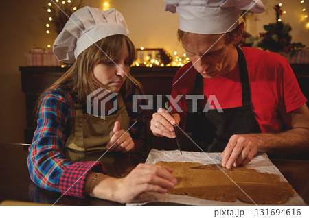 Cooking Friends Bake Gingerbread Cookies Together in a Cozy Christmas Kitchen 131694616