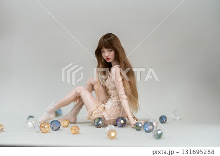 Fashion doll in dress sitting among colorful 131695288