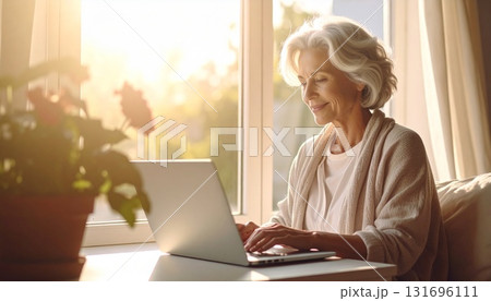 朝の光の中で副業する主婦の写真｜在宅ワーク・家庭・ノートパソコン 131696111