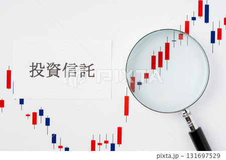 白背景に投資信託の文字と虫眼鏡で拡大したローソク足チャート 白背景に投資信託の文字と虫眼鏡で拡大したローソク足チャート 131697529
