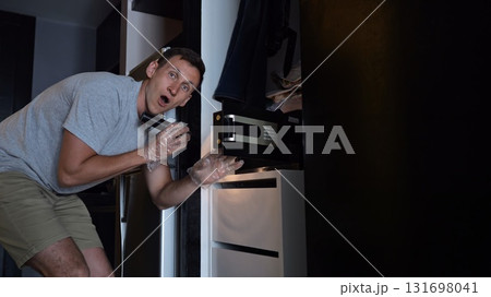 Thief opens hotel safe box lighting up face with excitement 131698041