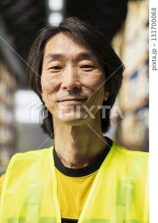 Asian business owner supervises order processing in a large scale logistics hub, coordinating express delivery and providing local customers with reliable service. Efficient e-commerce operations. Asian business owner supervises order processing in a large scale logistics hub, coordinating express delivery and providing local customers with reliable service. Efficient e-commerce operations. 131700068
