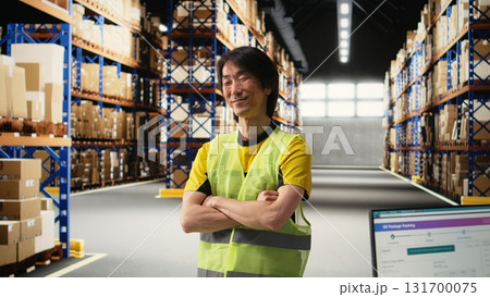 Asian male employee oversees product handling and order fulfillment, ensures inventory control using technology and packages coordination for efficient local delivery service. Camera A. Asian male employee oversees product handling and order fulfillment, ensures inventory control using technology and packages coordination for efficient local delivery service. Camera A. 131700075