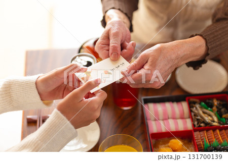 お正月の実家でおばあちゃんからお年玉をもらう孫の手 131700139