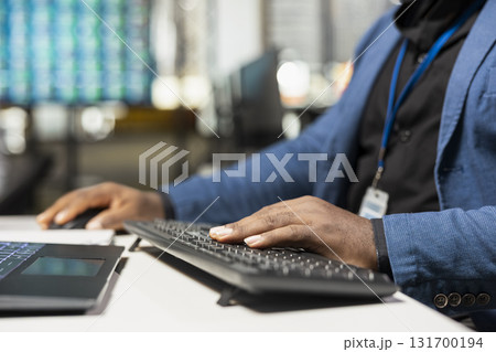 Close up of black male worker demonstrates a strategic mindset and analyzes business data with performance metrics. Managing report writing on computer at his workstation. Ensure growth. Close up of black male worker demonstrates a strategic mindset and analyzes business data with performance metrics. Managing report writing on computer at his workstation. Ensure growth. 131700194
