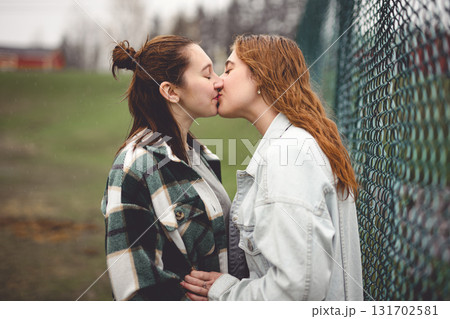 Lesbian Couple Together Outdoors in a rainy day 131702581