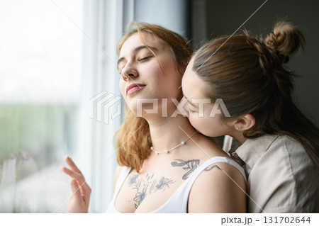 Happy couple having great time close to a window at home Happy couple having great time close to a window at home 131702644