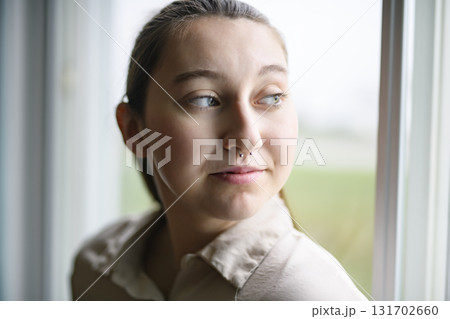 beautiful young woman in the bedroom close to a window beautiful young woman in the bedroom close to a window 131702660