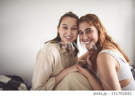 Happy couple cuddling on their bed at home. Romantic young LGBTQ 131702682