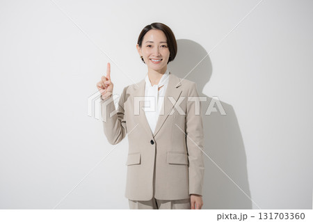 ベージュのスーツを着た立つ若い美人な女性のビジネス上半身のカメラ目線 白背景の営業などリクルート ベージュのスーツを着た立つ若い美人な女性のビジネス上半身のカメラ目線 白背景の営業などリクルート 131703360