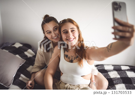 Happy couple cuddling on their bed at home. Romantic young LGBTQ Happy couple cuddling on their bed at home. Romantic young LGBTQ 131703533
