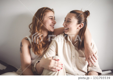 Happy couple cuddling on their bed at home. Romantic young LGBTQ 131703539