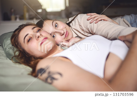 Happy couple cuddling on their bed at home. Romantic young LGBTQ 131703596
