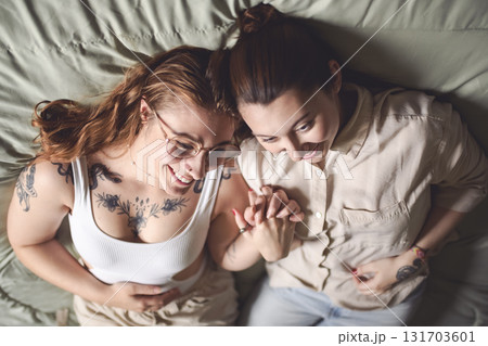 Happy couple cuddling on their bed at home. Romantic young LGBTQ 131703601