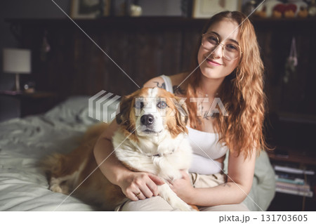Woman having great time with dog on bed Woman having great time with dog on bed 131703605