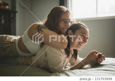 Happy couple cuddling on their bed at home. Romantic young LGBTQ Happy couple cuddling on their bed at home. Romantic young LGBTQ 131703699