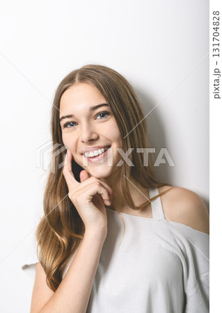 Portrait of teenage girl in casual t-shirt on light background in studio. 131704828