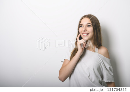 Portrait of teenage girl in casual t-shirt on light background in studio. Portrait of teenage girl in casual t-shirt on light background in studio. 131704835