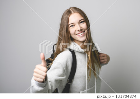 Portrait of teenage student girl in casual t-shirt on light background in studio. 131704874