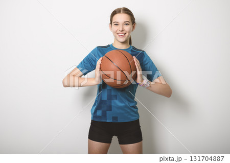 Basketball player holding ball on studio gray background Basketball player holding ball on studio gray background 131704887