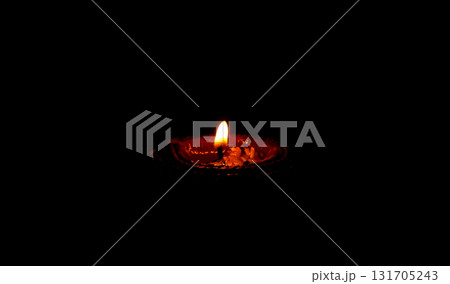 Burning Clay Oil Lamp in Darkness Symbolizing Light and Hope 131705243