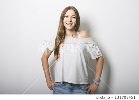 Portrait of teenage girl in casual t-shirt on light background in studio. Portrait of teenage girl in casual t-shirt on light background in studio. 131705451