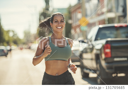 Happy sporty woman jogging outdoors in urban scene 131705685