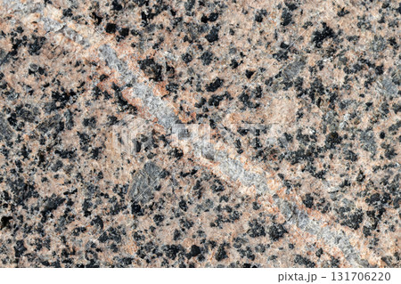Spotted granite stone texture, close up view with a white vein line Spotted granite stone texture, close up view with a white vein line 131706220