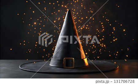 Black witch hat on a table with magical sparks floating in the dark background at night 131706728