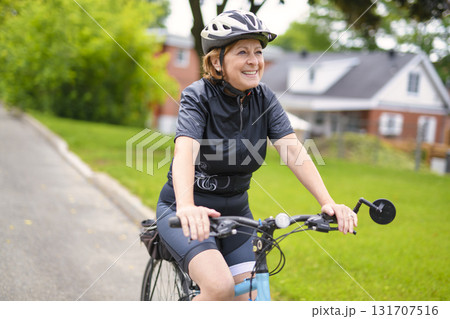 Happy mature cyclist woman enjoying healthy activity 131707516