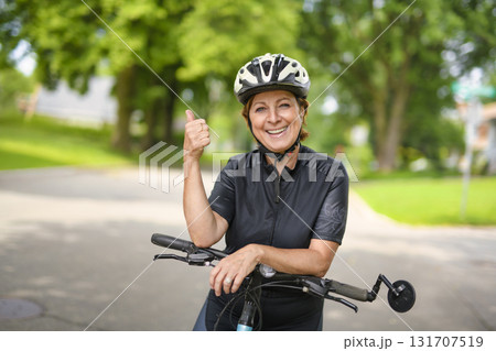 Happy mature cyclist woman enjoying healthy activity Happy mature cyclist woman enjoying healthy activity 131707519