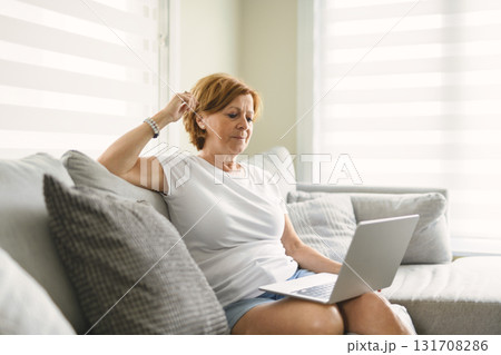 Happy modern European senior woman using laptop 131708286