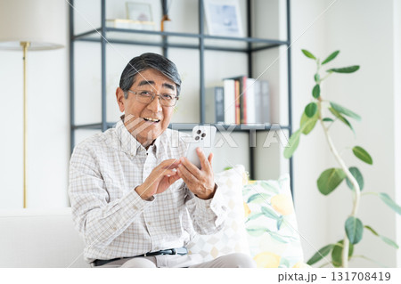 リビングでスマホを使うシニアの男性 131708419