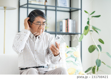 リビングでスマホを使うシニアの男性 リビングでスマホを使うシニアの男性 131708421