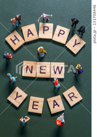 Miniature figurines surrounding wooden letter tiles forming the phrase Happy New Year Miniature figurines surrounding wooden letter tiles forming the phrase Happy New Year 131708446