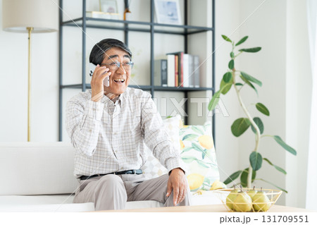 リビングで電話をするシニアの男性　 131709551