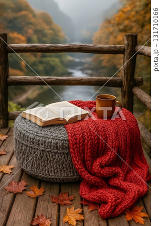 Cozy autumn reading scene with book mug and red knit blanket on deck 131710166