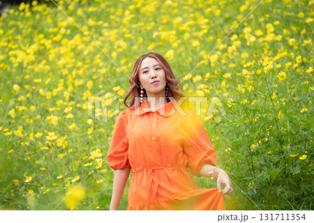 菜の花畑の前に立っている若い女性 菜の花畑の前に立っている若い女性 131711354