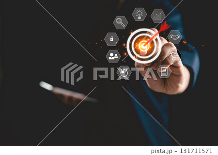 Businesswoman uses magnifying glass to focus on target board icon, symbolizing business concept of strategic planning, goal achievement, and innovation, key drivers of success in modern enterprises. 131711571