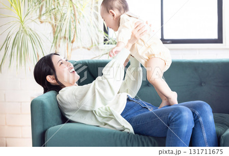 リビングでくつろぐ笑顔の若い親子 131711675