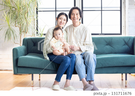 リビングでくつろぐ笑顔の若い家族 131711676